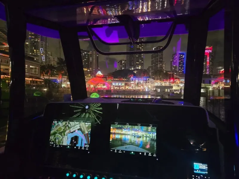 Slide: The Image of Cockpit view from 2022 Sea Hunt Gamefish 30, city skyline illuminated at night. - 25