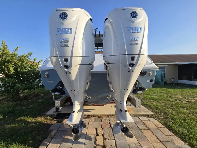 Slide: The Image of 2022 Sea Hunt Gamefish 30 with twin Yamaha 300 V6 engines, parked on a brick driveway. - 31