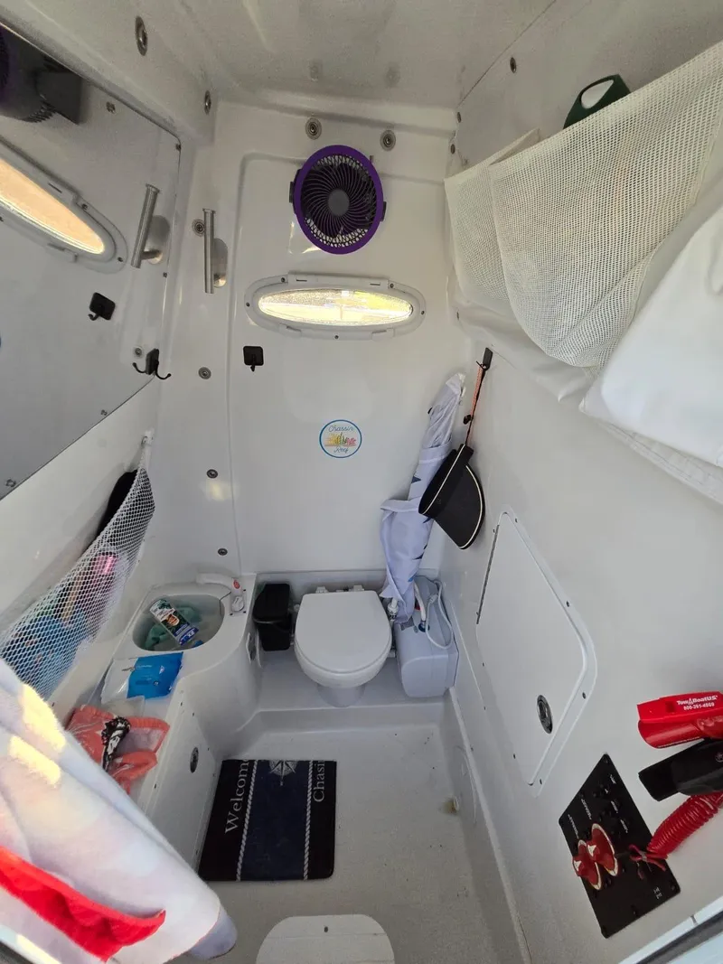 Slide: The Image of 2022 Sea Hunt Gamefish 30 cabin interior with toilet, storage, and accessories. - 44