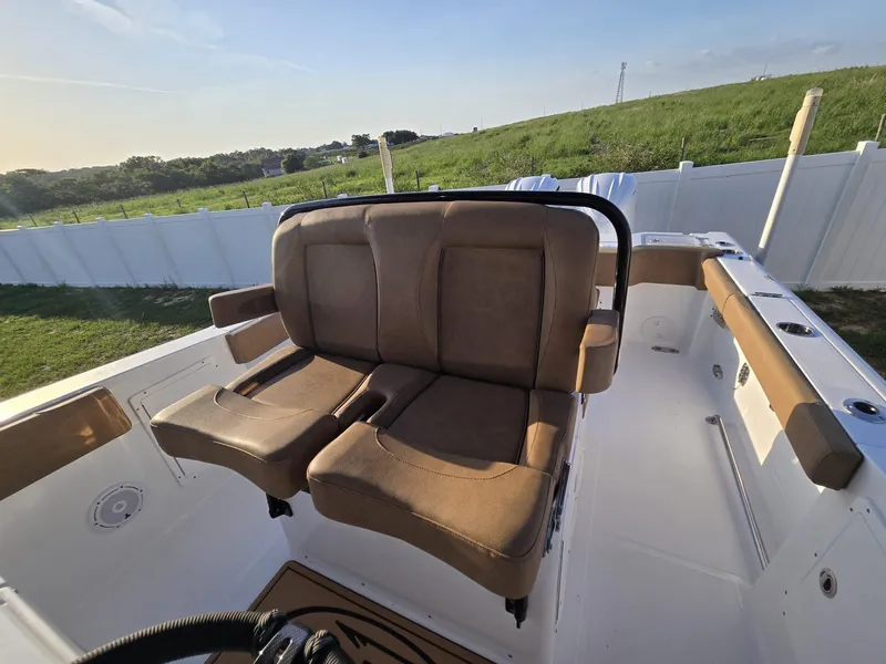 Slide: The Image of 2022 Sea Hunt Gamefish 30 Forward Seating with brown cushioned seats, outdoor setting. - 45
