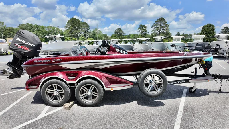 Slide: The Image of 2018 Ranger Z 518c boat with Mercury engine, parked outdoors under a cloudy sky. - 14