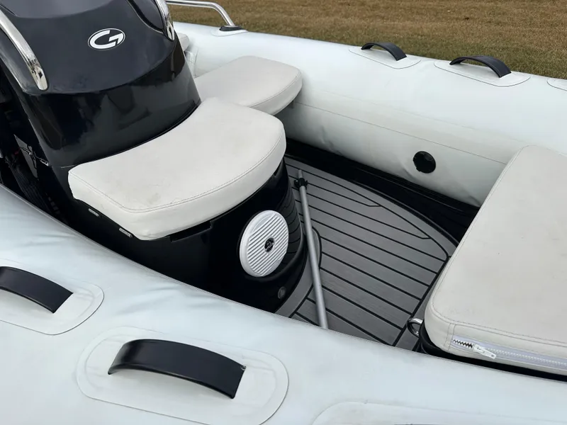Slide: The Image of 2022 Grand Inflatables G380 boat interior with cushioned seating and sleek design. - 10
