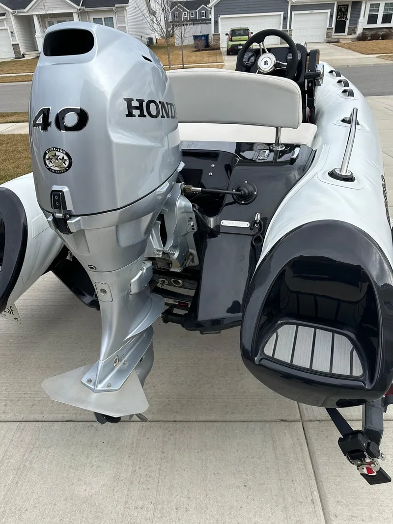 Slide: The Image of 2022 Grand Inflatables G380 with Honda 40 outboard motor on a driveway. - 4