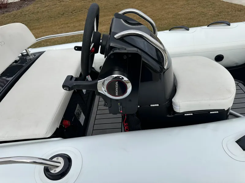 Slide: The Image of 2022 Grand Inflatables G380 boat interior with steering wheel and seating. - 5