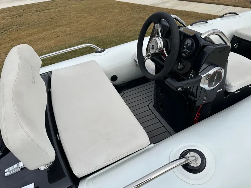 Slide: The Image of 2022 Grand Inflatables G380 boat interior with steering wheel and seating. - 6