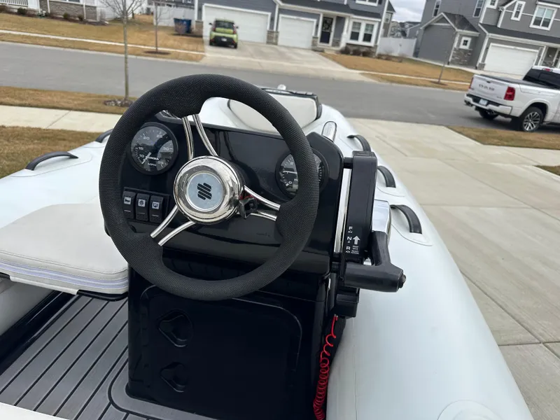 Slide: The Image of 2022 Grand Inflatables G380 boat steering console with gauges and controls. - 7