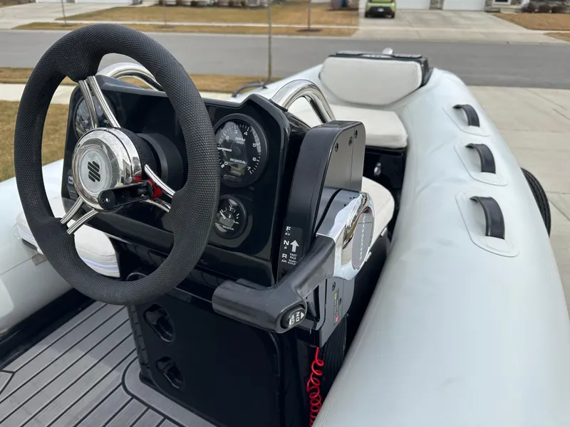 Slide: The Image of 2022 Grand Inflatables G380 boat interior with steering wheel and dashboard controls. - 8