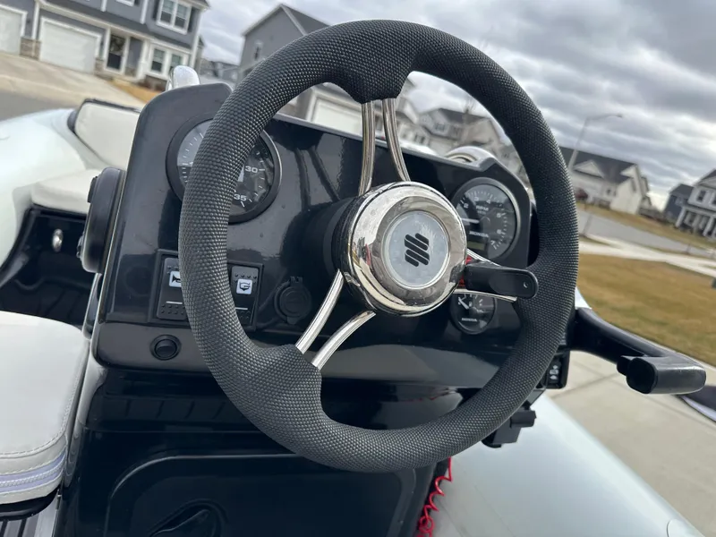 Slide: The Image of Steering wheel of 2022 Grand Inflatables G380 boat, featuring dashboard controls and gauges. - 9
