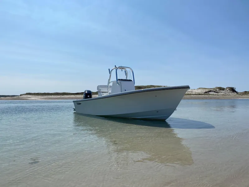 Slide: The Image of 2023 Pair Customs 21 Center Console DV boat on calm water near sandy shore. - 2
