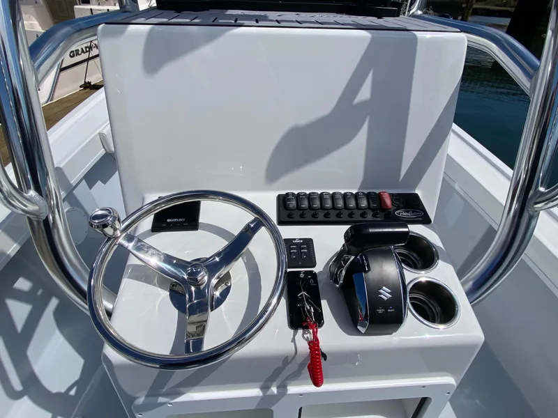 Slide: The Image of 2023 Pair Customs 21 Center Console DV boat dashboard with steering wheel and controls. - 7