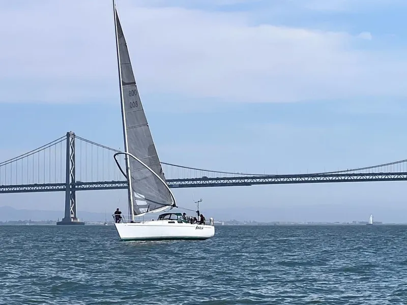 The Image of Sailboat Wyliecat 48 (2000) cruising near a large bridge on a clear day. - 1