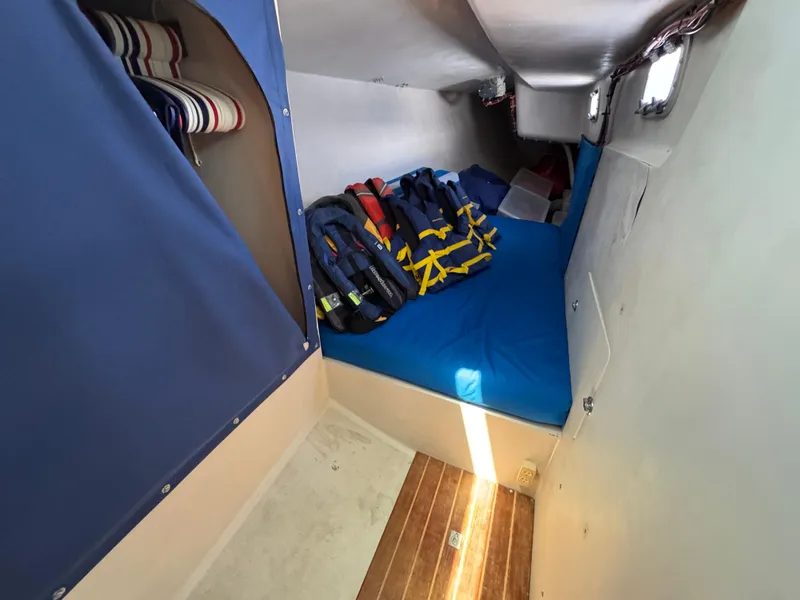 Slide: The Image of Cabin interior of 2000 Wyliecat 48 sailboat with life jackets and blue bedding. - 11