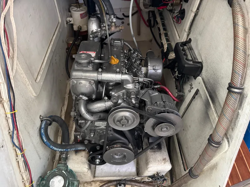 Slide: The Image of Engine compartment of a 2000 Wyliecat 48 sailboat, showcasing mechanical components and belts. - 17