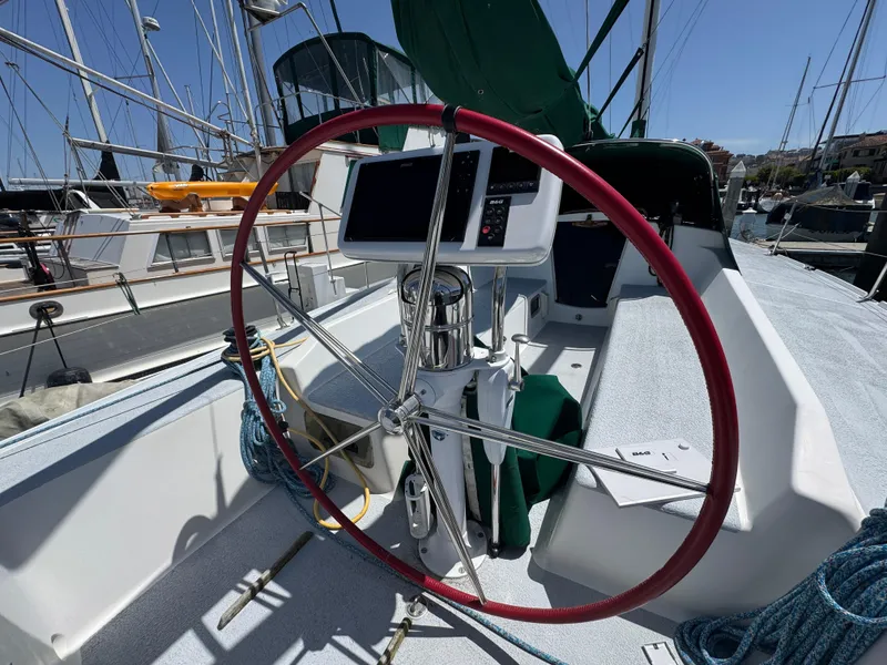 Slide: The Image of Sailboat cockpit of a 2000 Wyliecat 48 with red steering wheel and navigation equipment. - 18