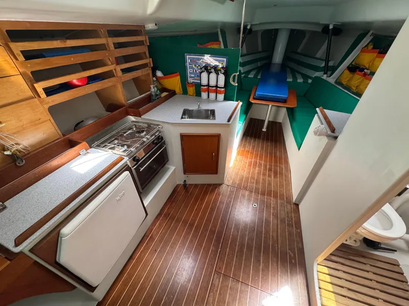 Slide: The Image of Interior of a 2000 Wyliecat 48 sailboat with kitchen and seating area. - 9