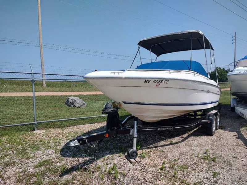 Slide: The Image of 1994 Sea Ray 220 Bow Rider boat on trailer, parked outdoors under clear sky. - 10