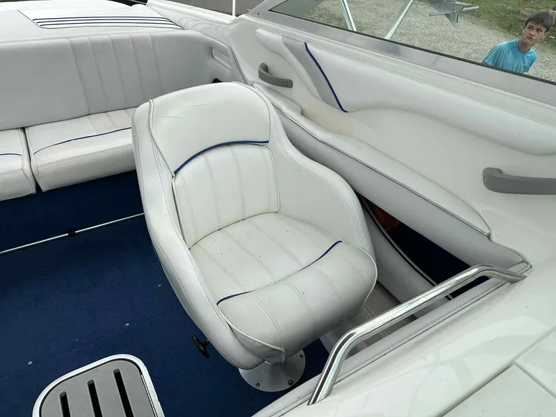Slide: The Image of 1994 Sea Ray 220 Bow Rider interior with white seating and blue accents. - 16