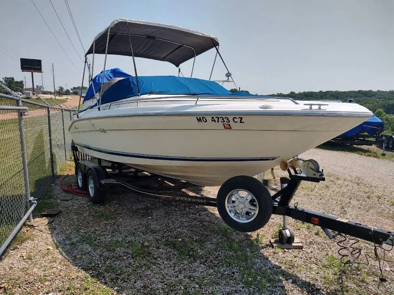 Slide: The Image of 1994 Sea Ray 220 Bow Rider boat on trailer, parked outdoors. - 17