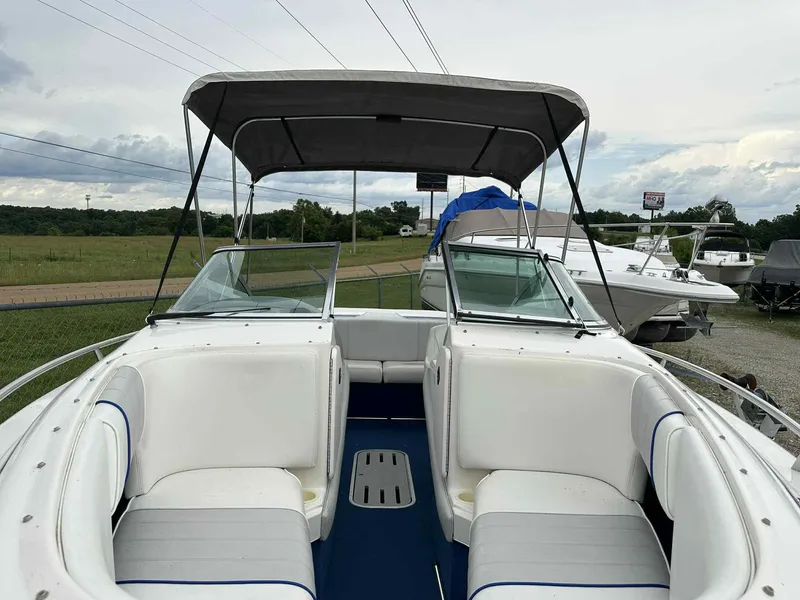 Slide: The Image of 1994 Sea Ray 220 Bow Rider boat with canopy, white seating, and blue flooring. - 20