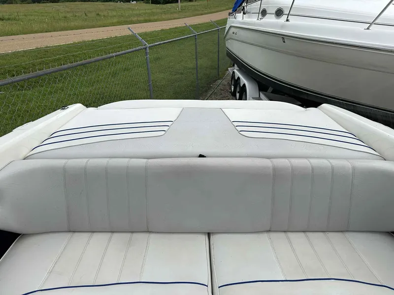 Slide: The Image of 1994 Sea Ray 220 Bow Rider boat interior with white cushioned seating. - 29
