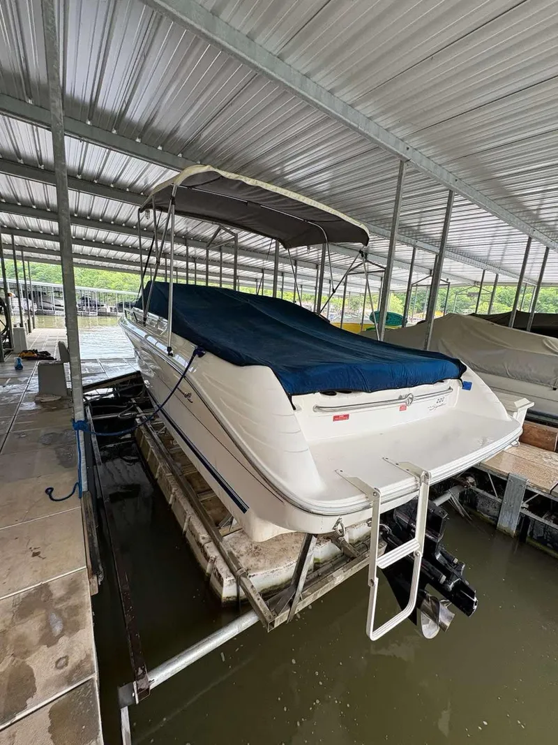 Slide: The Image of 1994 Sea Ray 220 Bow Rider boat docked under a metal canopy. - 3