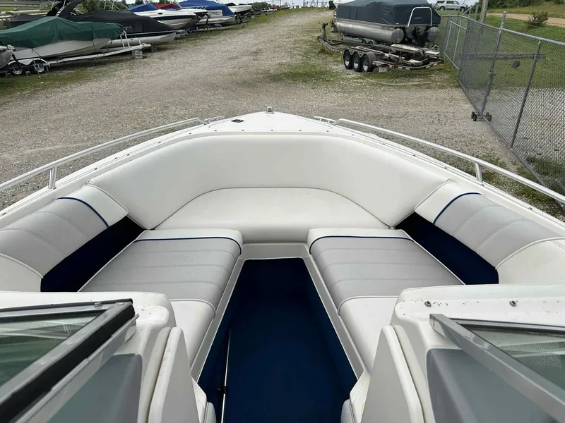 Slide: The Image of 1994 Sea Ray 220 Bow Rider boat with spacious seating, parked in a marina. - 31