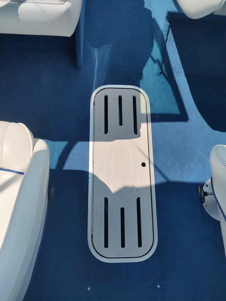Slide: The Image of Interior of a 1994 Sea Ray 220 Bow Rider with blue carpet and white seating. - 5