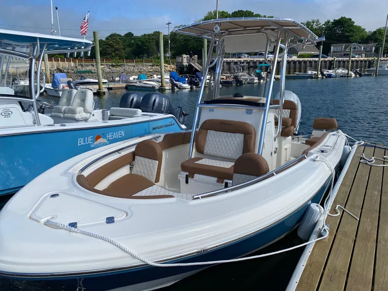 Slide: The Image of 2023 Pioneer 202 Sportfish boat docked at marina, featuring sleek design and comfortable seating. - 2