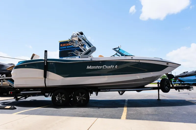 Slide: The Image of 2025 MasterCraft X26 boat on trailer in parking lot, side view. - 12