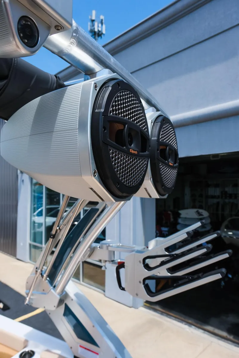 Slide: The Image of 2025 MasterCraft X26 boat speakers and wakeboard rack in a marina setting. - 18