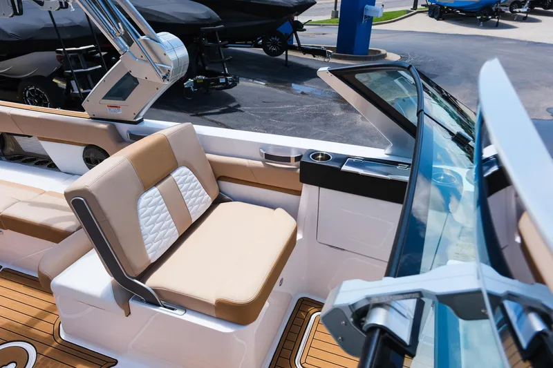 Slide: The Image of 2025 MasterCraft X26 boat interior with beige seating and modern dashboard. - 23