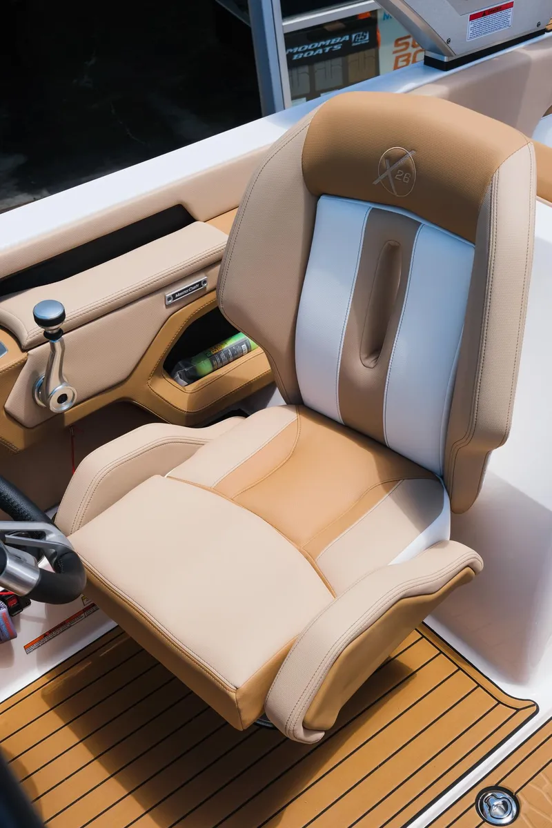 Slide: The Image of 2025 MasterCraft X26 captain's chair with tan and white upholstery, showcasing luxury design. - 24