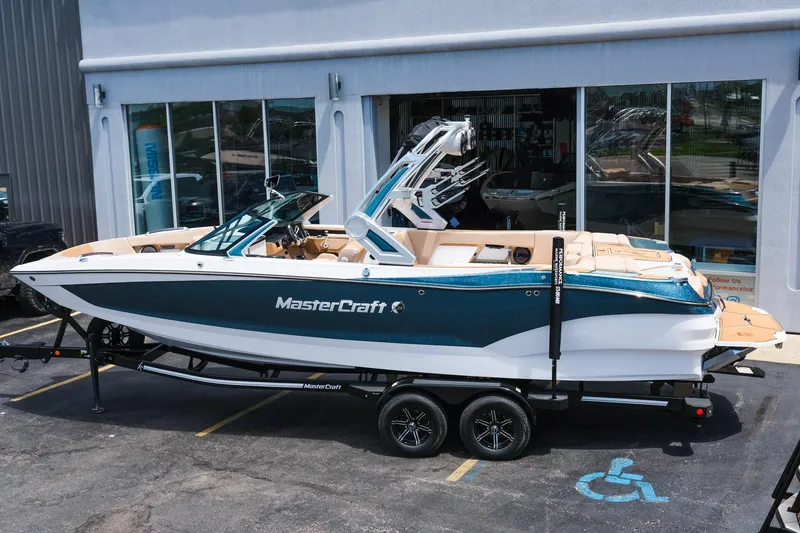 Slide: The Image of 2025 MasterCraft X26 boat on trailer, parked outside a showroom. - 3