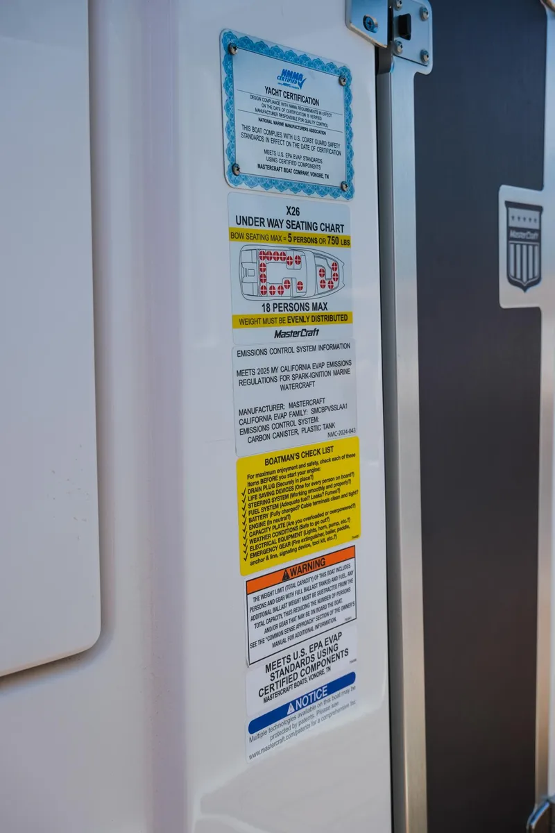 Slide: The Image of 2025 MasterCraft X26 safety and capacity labels on boat interior. - 30