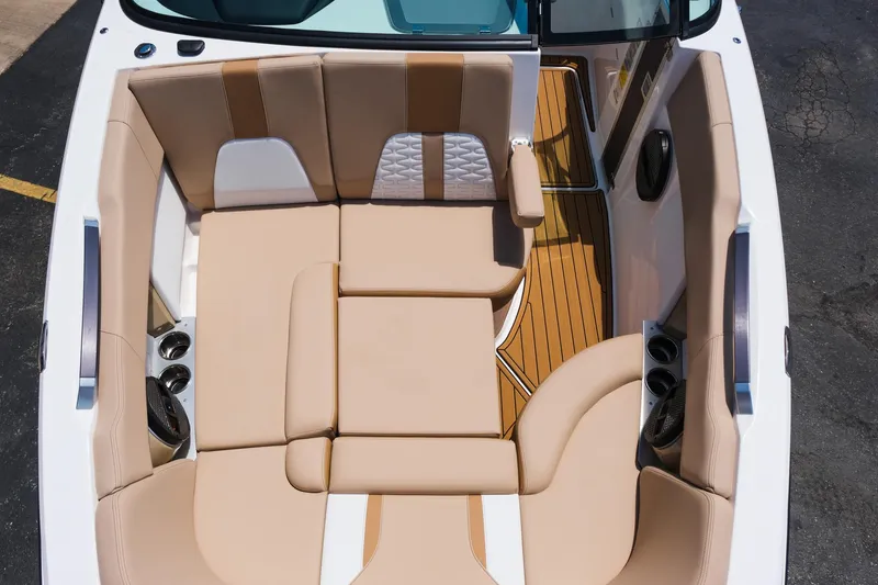 Slide: The Image of 2025 MasterCraft X26 boat interior with beige seating and wood accents. - 34