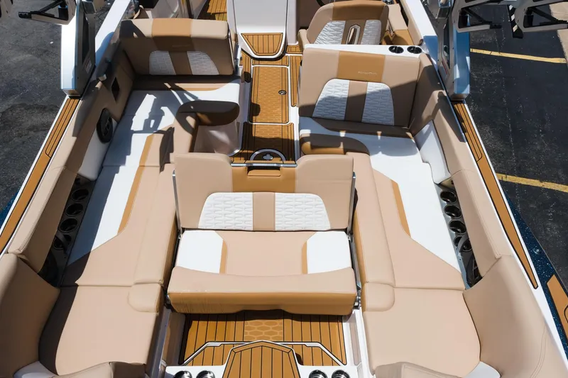 Slide: The Image of 2025 MasterCraft X26 boat interior with luxurious tan and white seating, wood accents, and cup holders. - 35