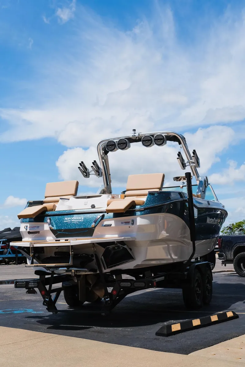 Slide: The Image of 2025 MasterCraft X26 boat on trailer under blue sky. - 37