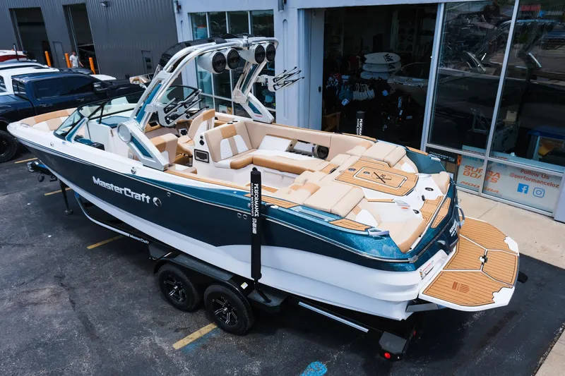 Slide: The Image of 2025 MasterCraft X26 boat on trailer, parked outside a showroom. - 4