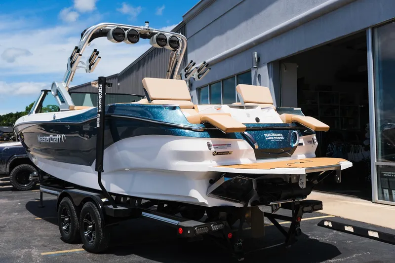 Slide: The Image of 2025 MasterCraft X26 boat with sleek design, parked on a trailer outside a building. - 8