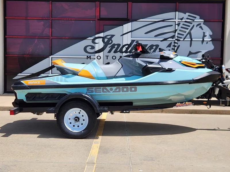 Slide: The Image of 2022 Sea-Doo Wake Pro 230 jet ski on trailer, parked outside dealership. - 1