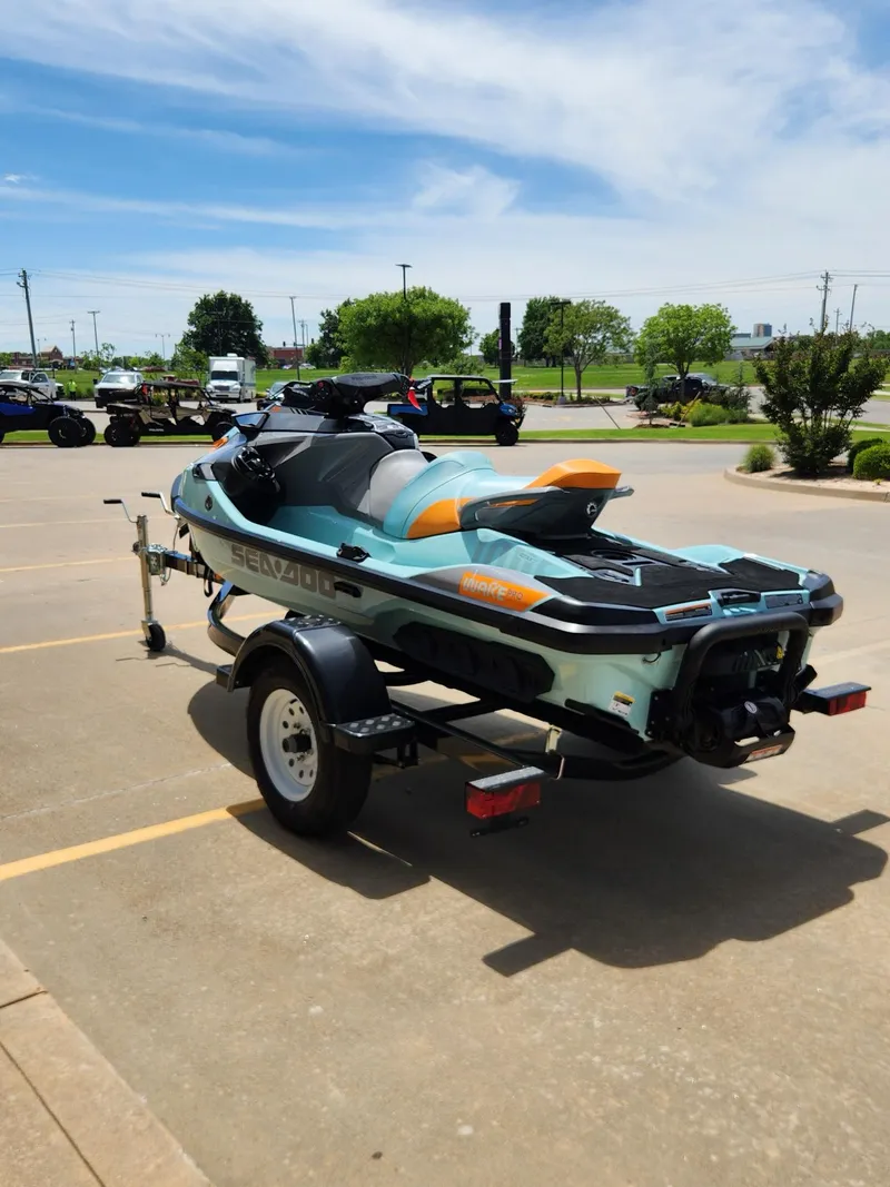 Slide: The Image of 2022 Sea-Doo Wake Pro 230 on trailer in parking lot, under clear blue sky. - 6