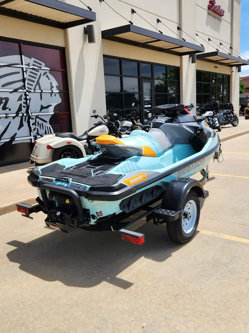 Slide: The Image of 2022 Sea-Doo Wake Pro 230 on trailer outside dealership, parked beside motorcycles. - 8