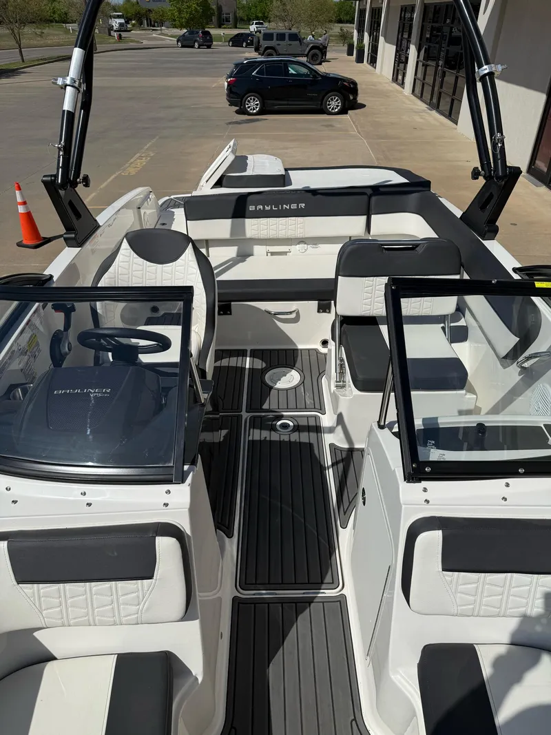 Slide: The Image of 2021 Bayliner VR5 Bowrider I/O interior with seating and steering wheel, parked outdoors. - 19
