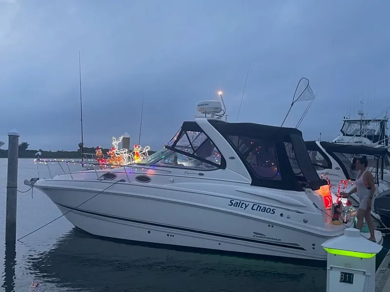 Slide: The Image of 2003 Chaparral Signature 290 boat, named "Salty Chaos," docked with festive lights. - 2