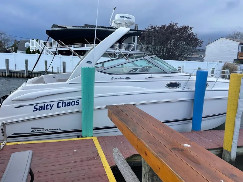Slide: The Image of 2003 Chaparral Signature 290 boat named "Salty Chaos" docked at a marina. - 3