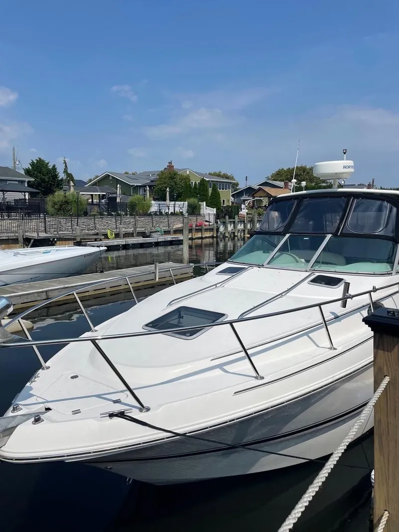 Slide: The Image of 2003 Chaparral Signature 290 boat docked at a marina under a clear blue sky. - 6