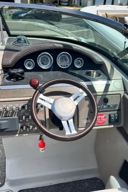 Slide: The Image of 2011 Sea Ray 250 SLX boat dashboard with steering wheel and instrument panel. - 2