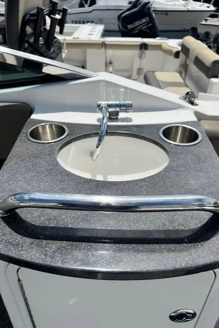 Slide: The Image of 2011 Sea Ray 250 SLX boat sink with faucet and cup holders on deck. - 5