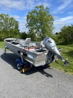 Slide: The Image of 1979 Sea Nymph Jon boat with outboard motor on a trailer, parked outdoors. - 3