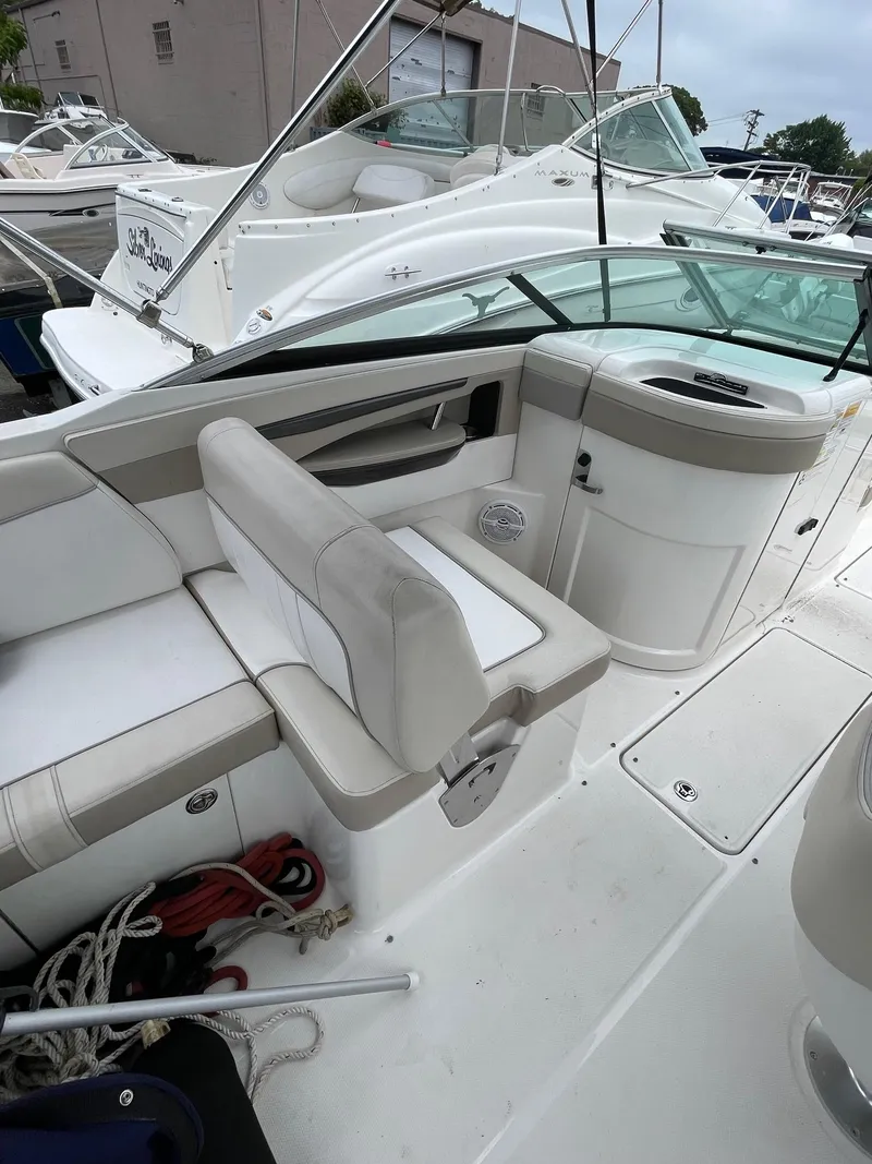 Slide: The Image of 2013 Sea Ray 240 Sundeck boat interior with white seating and storage compartments. - 12